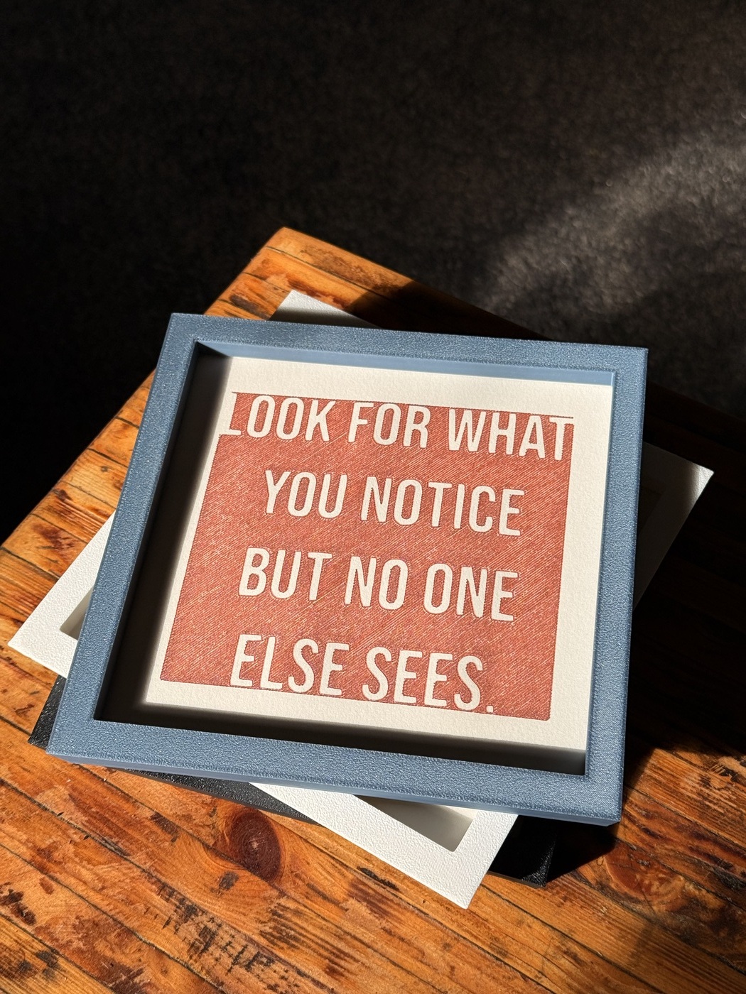 Handgezeichneter Spruch 'Look for what you notice but no one else sees' im blauen Rahmen, personalisiertes Wandbild mit Zitat