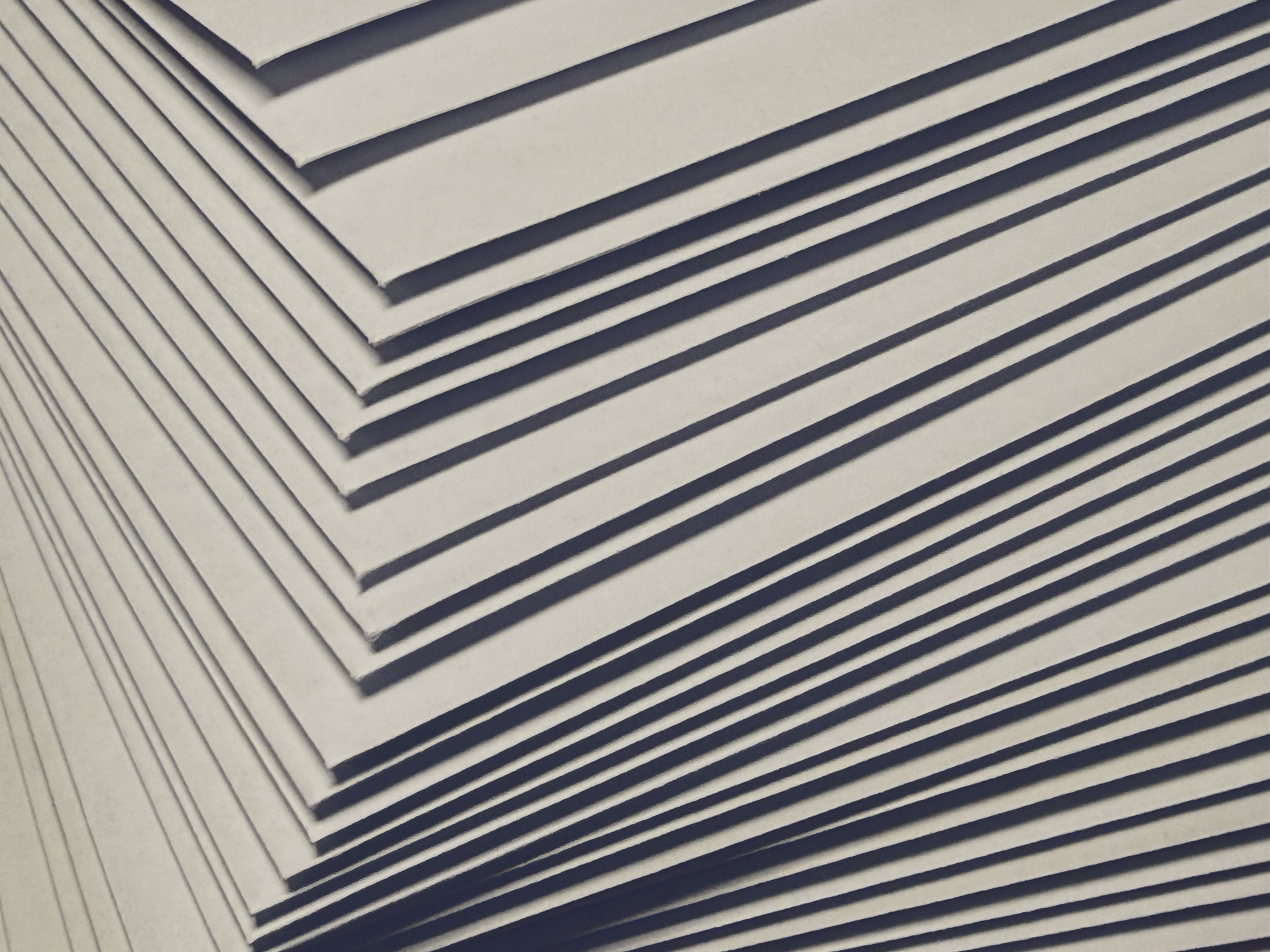 Gestapelte Briefumschläge von der Seite — diagonale Papierlagen, jeder Umschlag einzeln beschriftet