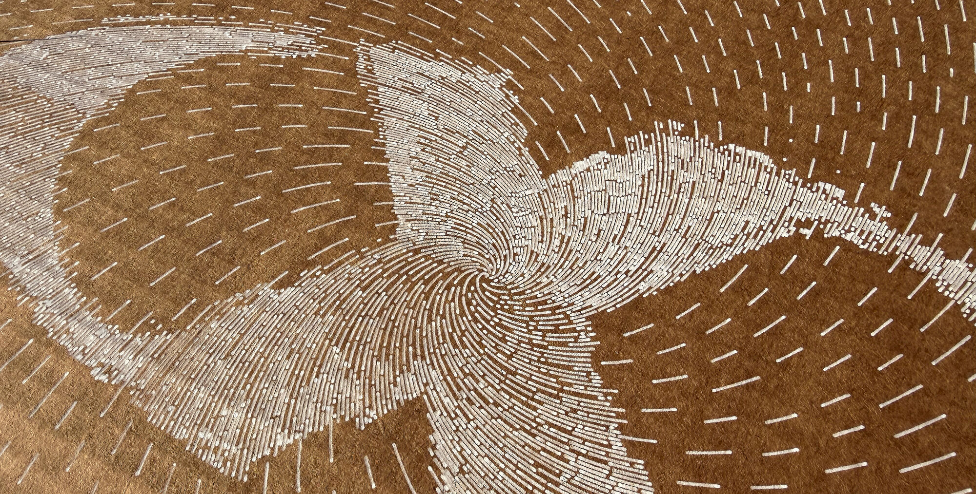 Makroaufnahme einer Stiftplotter-Spiralzeichnung in Weiß auf Naturpapier — Liniendichte aus nächster Nähe