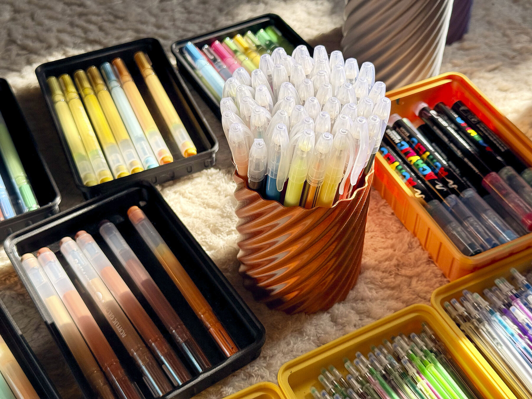 Sortierte Stiftboxen mit Fasermalern, Fineliner und Gelpens für Paketbeileger in verschiedenen Farben