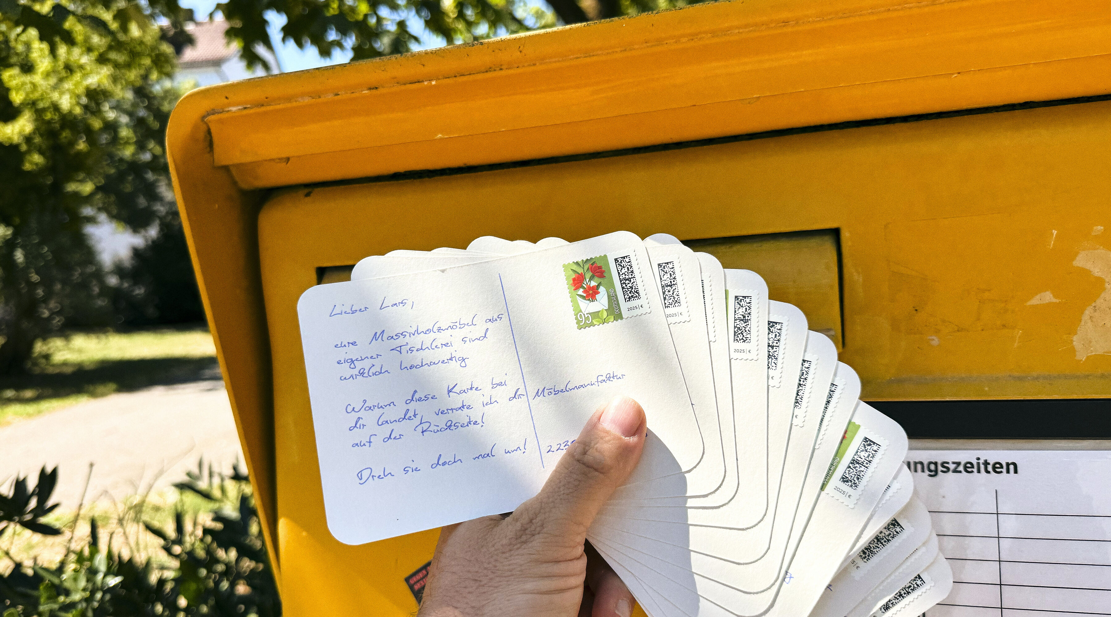 Mehrere handgeschriebene Postkarten aufgefächert am Briefkasten, bereit zum Versand — Farming-Kampagne für Immobilienmakler