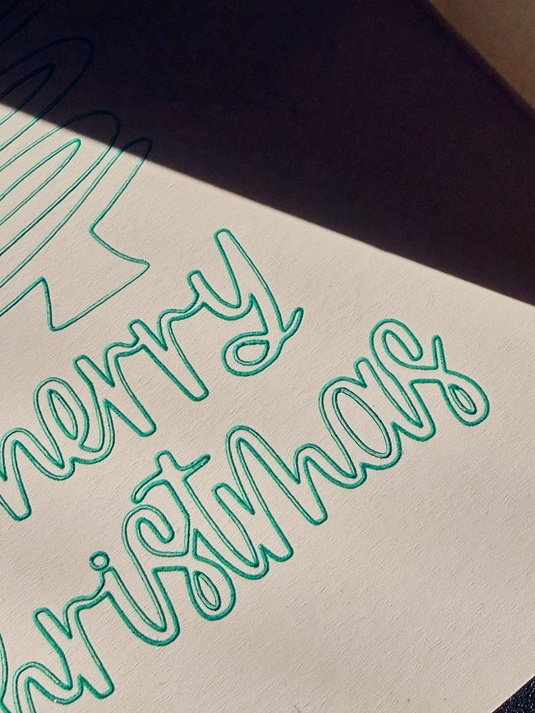 Weihnachtskarte 'Merry Christmas' in grüner Handschrift für internationale Geschäftspartner